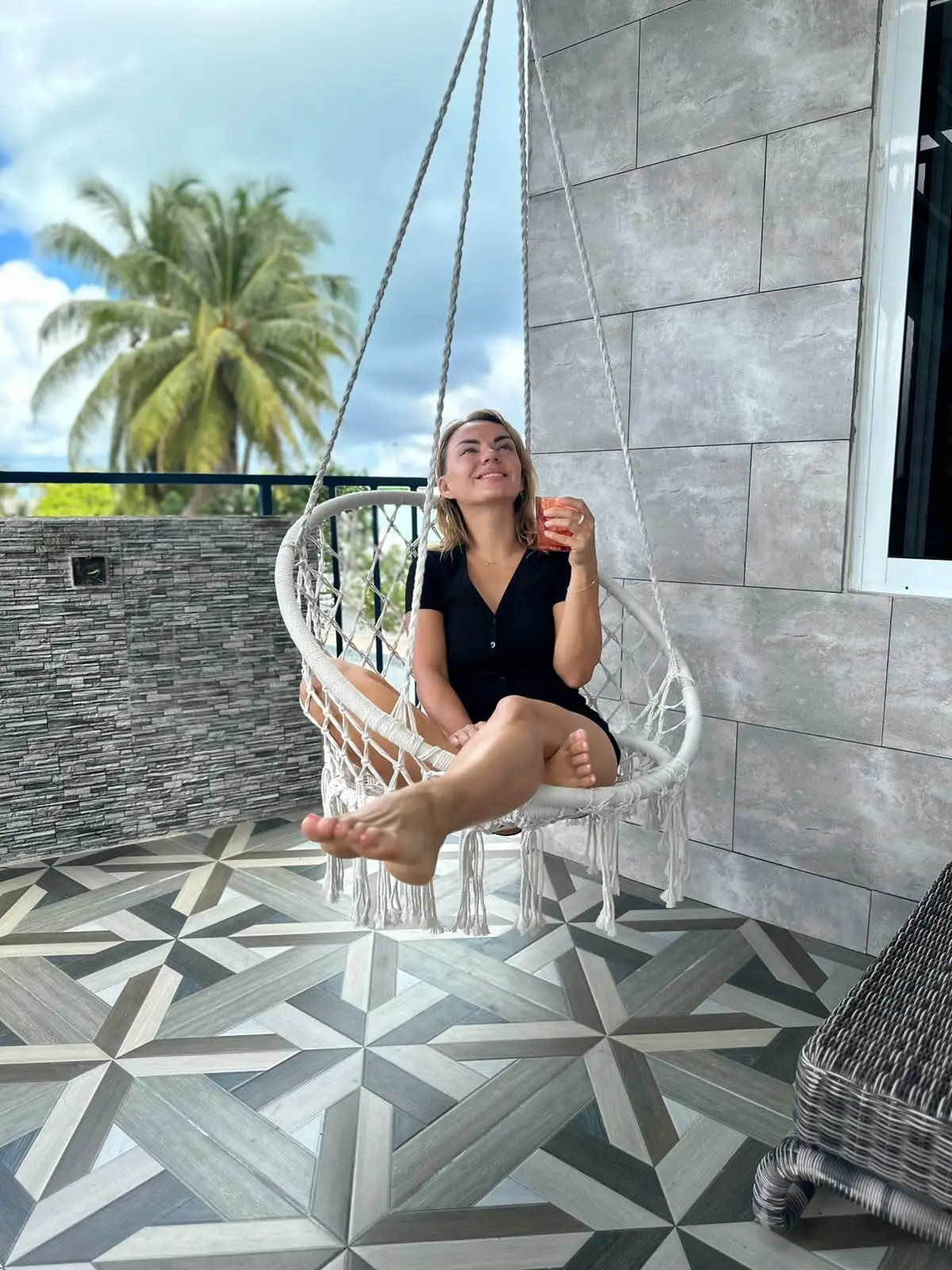 Guest relaxing on a hanging chair on a private sun terrace at Koimala Maamigili