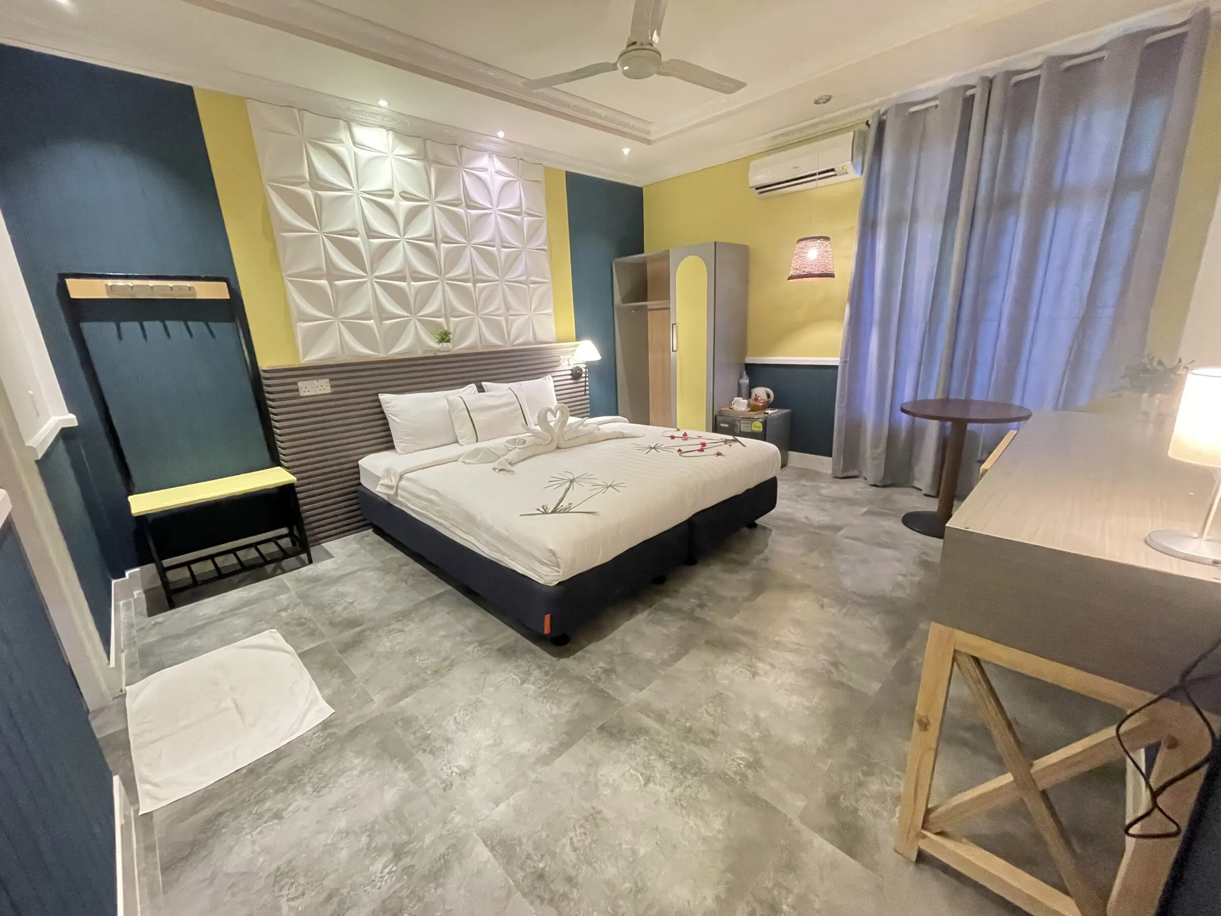 Deluxe room with a double bed and green patterned feature wall at Koimala Maamigili