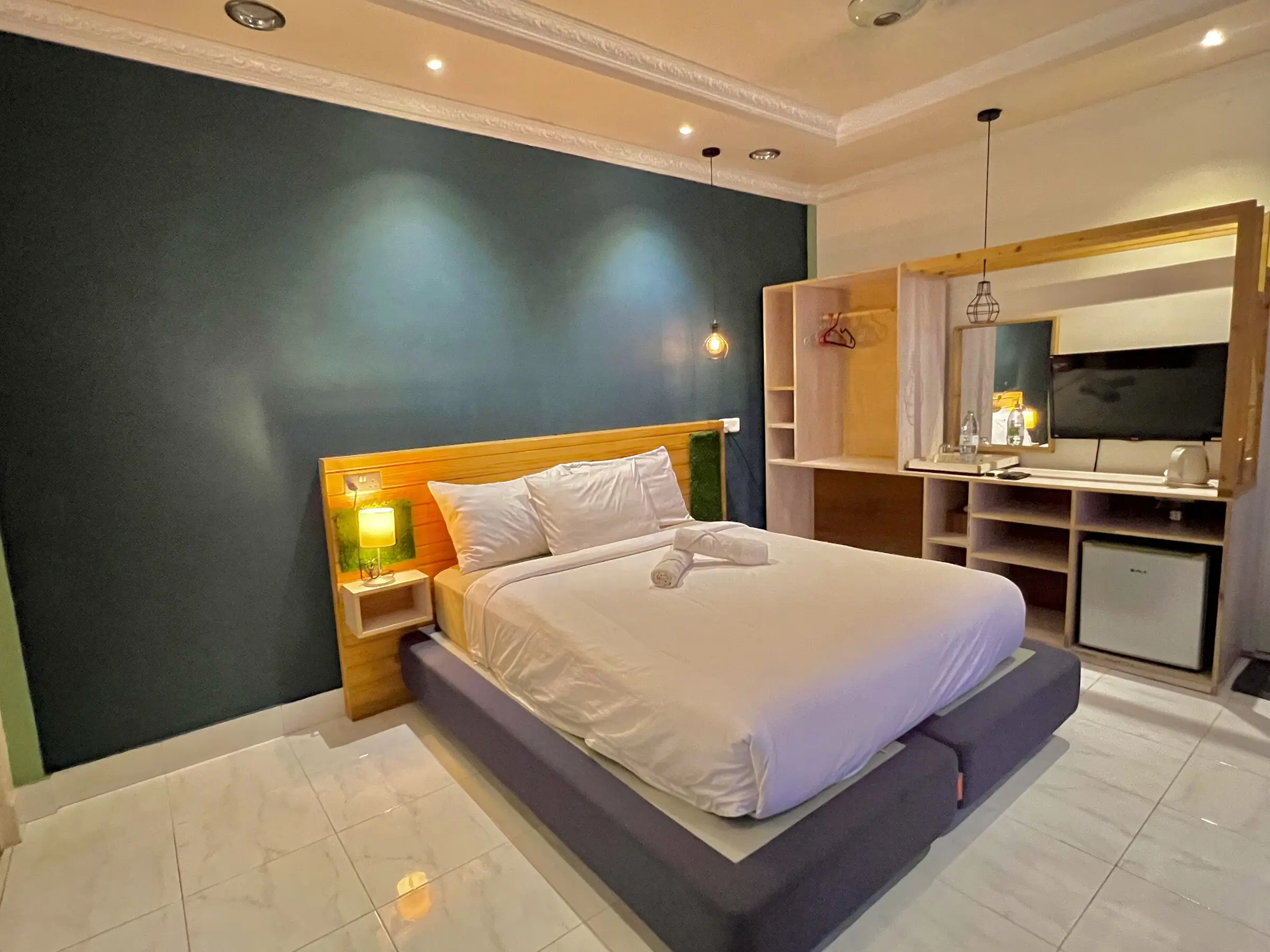 Double room with warm lighting and a dark accent wall at Koimala Maamigili