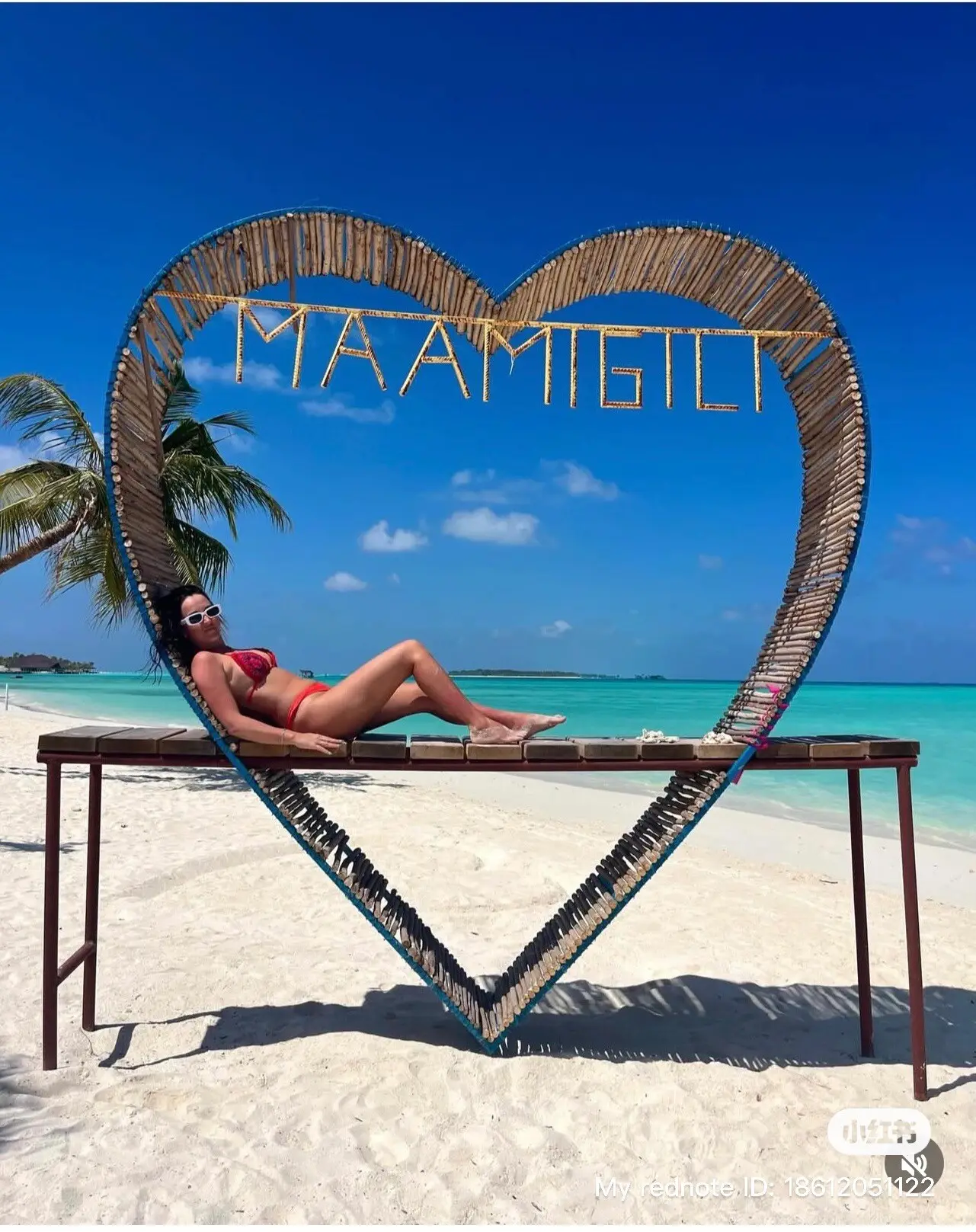 Guest resting in the Maamigili heart-shaped beach frame