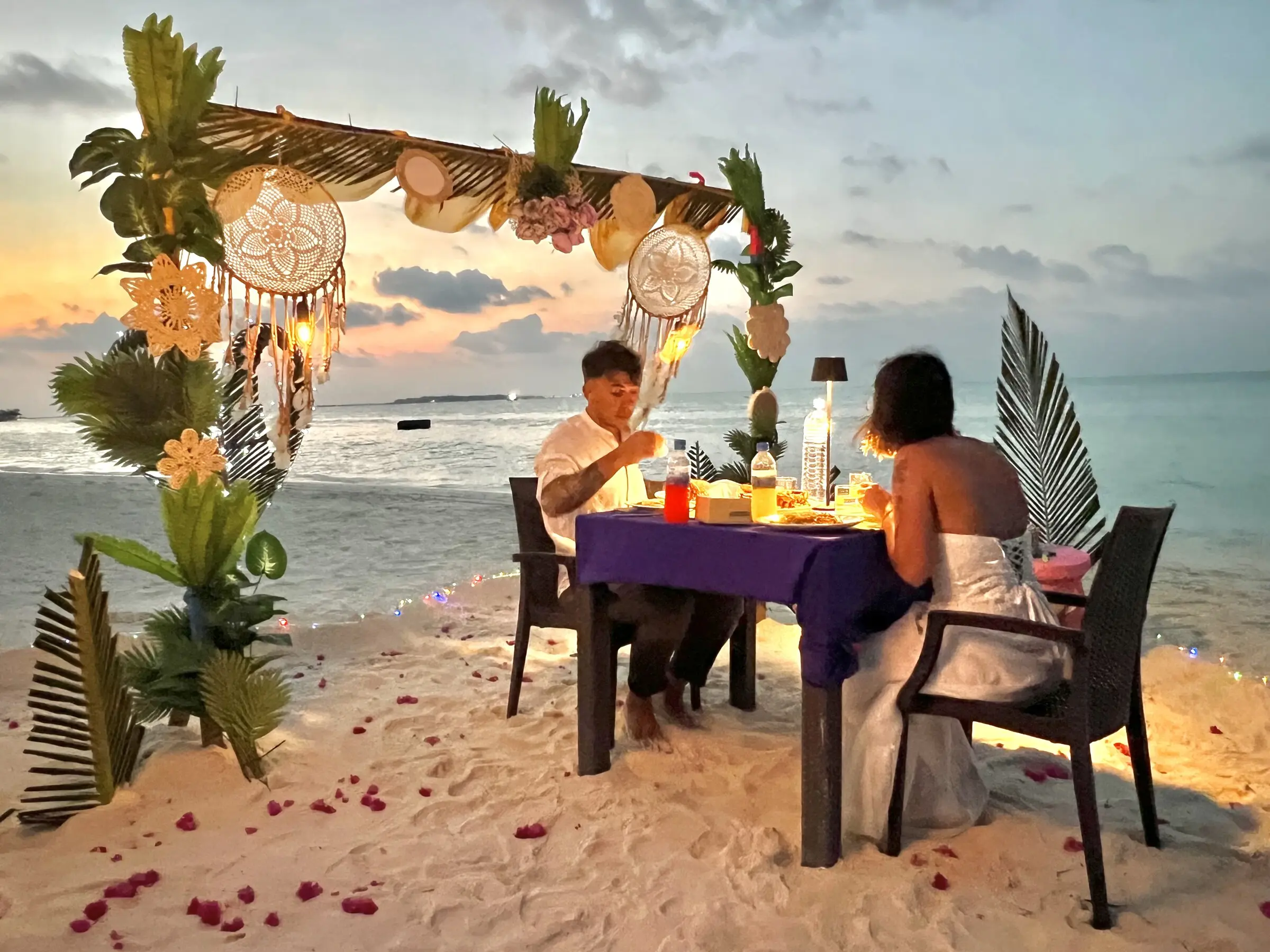Private romantic beach dinner set with flowers on Maamigili