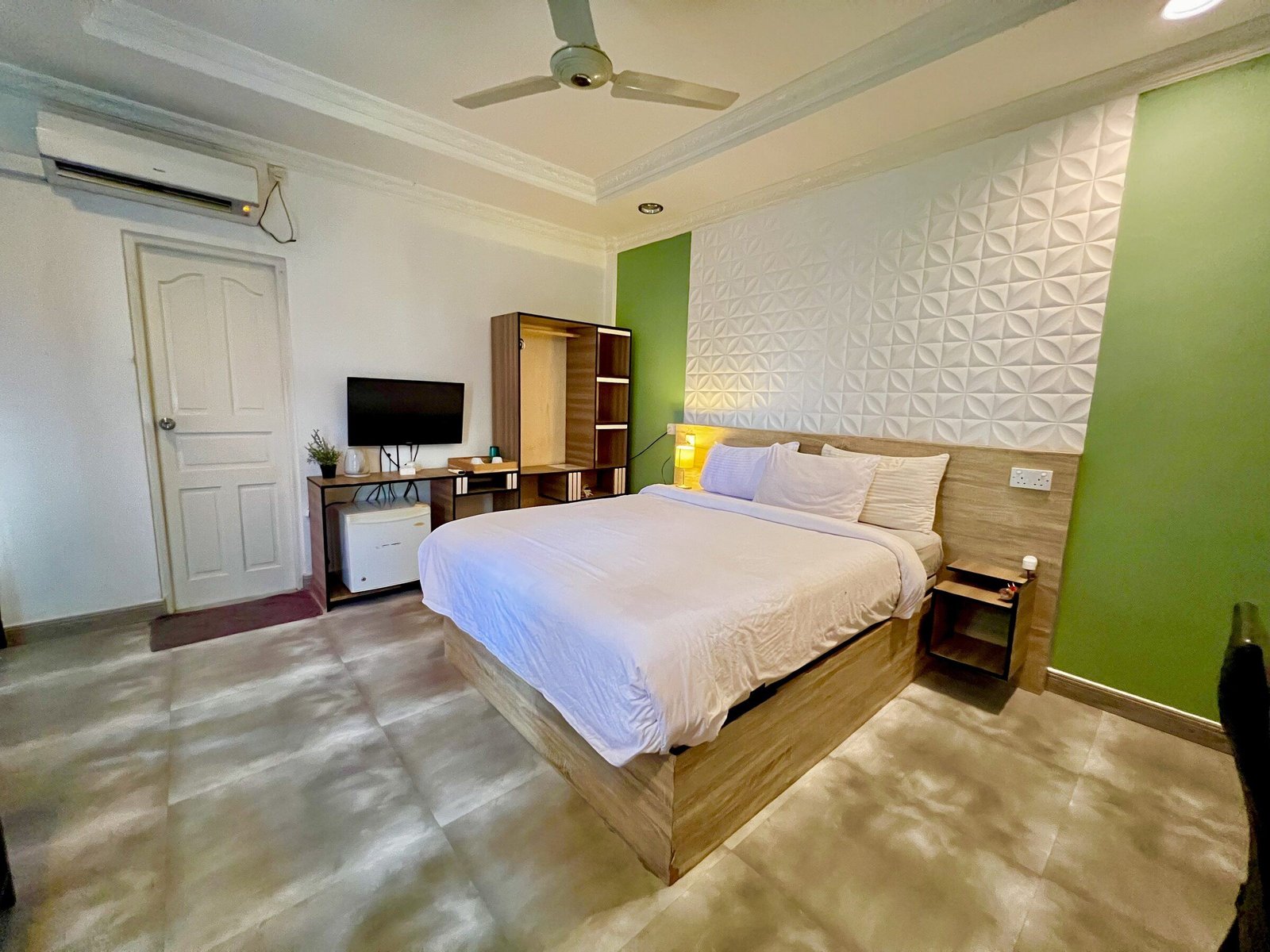 Deluxe Room with a double bed and green feature wall at Koimala Maamigili